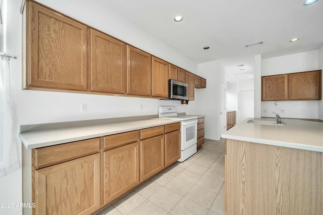 kitchen with white electric range, light tile patterned floors, and sink