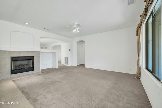 unfurnished living room with light carpet, a fireplace, and ceiling fan