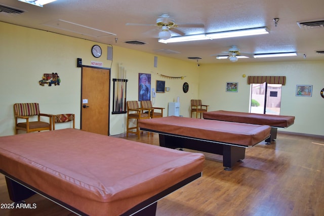 playroom featuring hardwood / wood-style floors, a textured ceiling, ceiling fan, and billiards