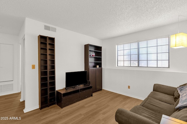 3491 N Arizona Ave Unit 118, Chandler, AZ 85225 - living room featuring light wood-style flooring, a textured ceiling, and baseboards