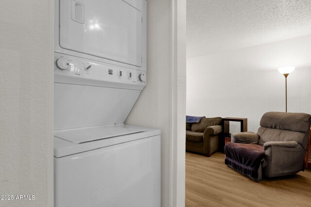 3491 N Arizona Ave Unit 118, Chandler, AZ 85225 - washroom featuring estacked washer and dryer, light wood-type flooring, and a textured ceiling