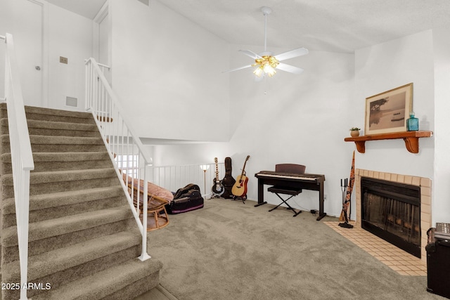 3491 N Arizona Ave Unit 118, Chandler, AZ 85225 - living room featuring a ceiling fan, carpet flooring, stairs, a tile fireplace, and vaulted ceiling