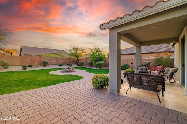 patio terrace at dusk with an outdoor living space and a lawn