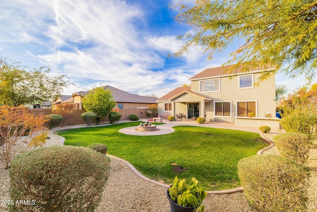 back of property featuring a fire pit, a lawn, and a patio