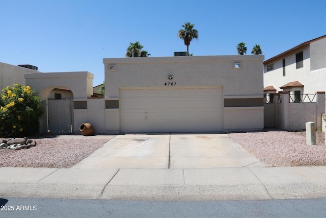 4767 W Wahalla Ln, Glendale, AZ 85308 - pueblo revival-style home featuring a gate, concrete driveway, stucco siding, and a garage
