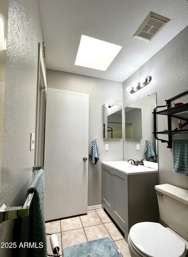 4767 W Wahalla Ln, Glendale, AZ 85308 - bathroom featuring a textured wall, vanity, a skylight, and tile patterned floors