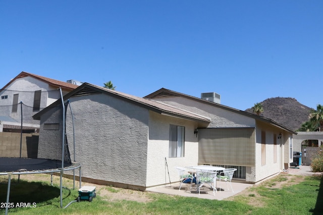4767 W Wahalla Ln, Glendale, AZ 85308 - rear view of property featuring a trampoline, a patio area, stucco siding, and a lawn