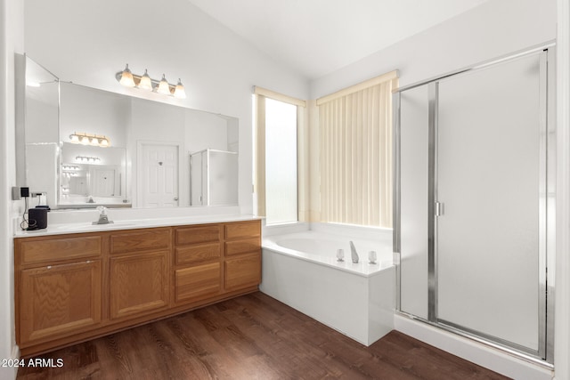 bathroom with hardwood / wood-style flooring, vanity, lofted ceiling, and independent shower and bath