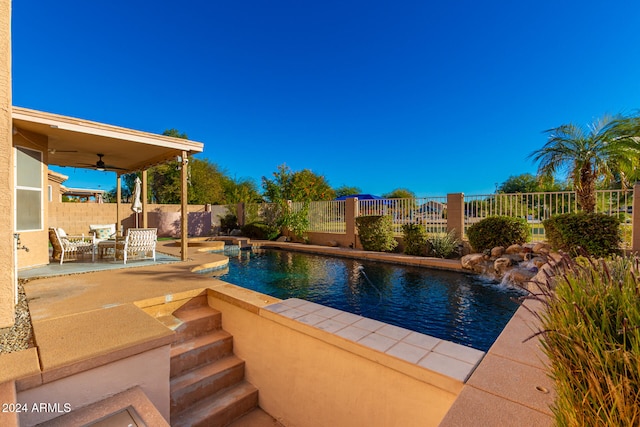 view of swimming pool with pool water feature, ceiling fan, and a patio area