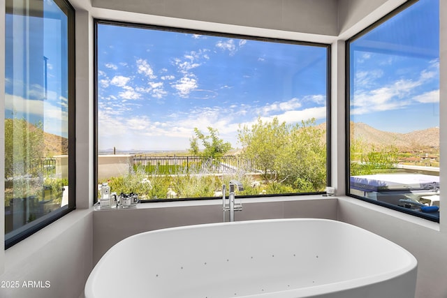 bathroom featuring a bathing tub and a mountain view