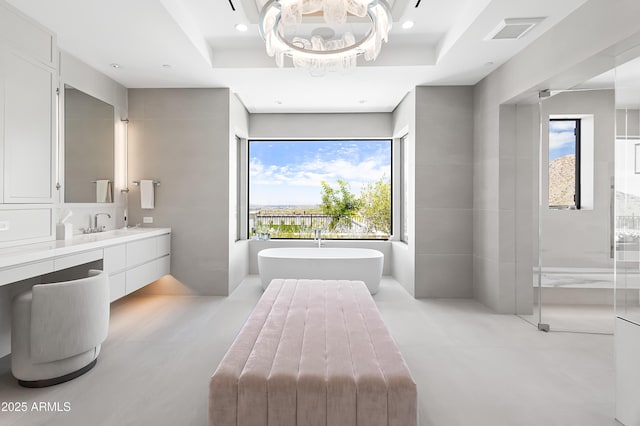 bathroom with vanity, shower with separate bathtub, and a raised ceiling