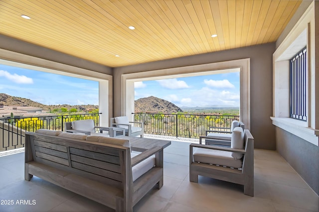 view of patio with an outdoor living space, a balcony, and a mountain view