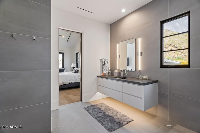 bathroom with vanity, tile walls, and a healthy amount of sunlight