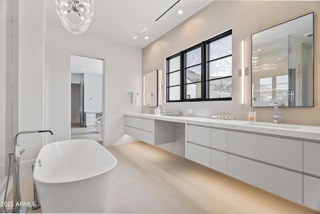 bathroom featuring an inviting chandelier, vanity, and independent shower and bath