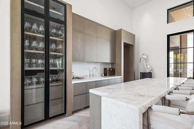 kitchen featuring light parquet floors, sink, and a breakfast bar area