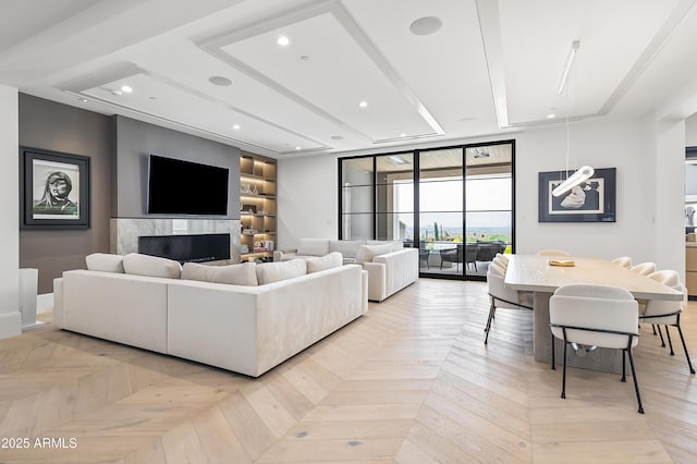 living room featuring a raised ceiling and light parquet floors