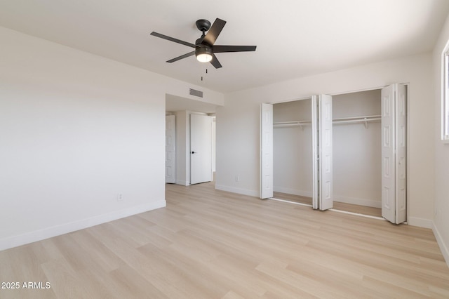 14803 N 55th Ave, Glendale, AZ 85306 - unfurnished bedroom featuring two closets, ceiling fan, light wood-type flooring, visible vents, and baseboards