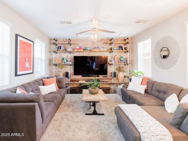 living area featuring visible vents and a ceiling fan