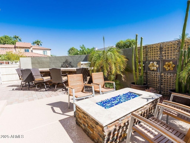 view of patio / terrace with a fire pit and fence