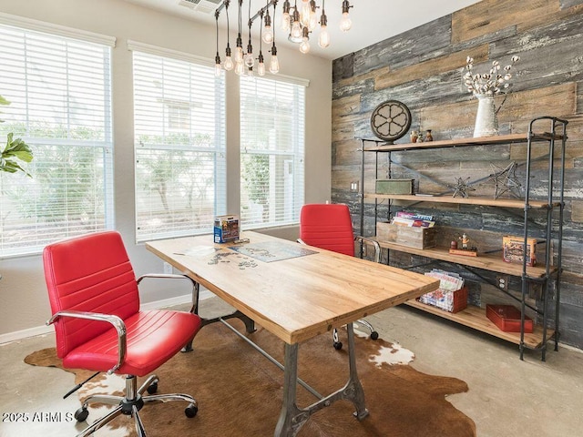 home office with concrete floors, wood walls, and baseboards