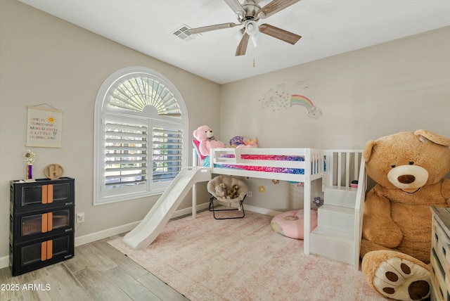 bedroom with light wood-style floors, visible vents, baseboards, and a ceiling fan