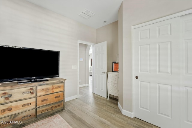 bedroom featuring light wood-style flooring, visible vents, and baseboards