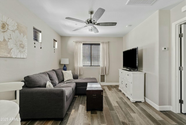 living room with baseboards, ceiling fan, visible vents, and wood finished floors