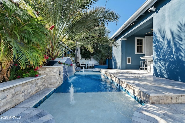 view of pool with a patio and pool water feature