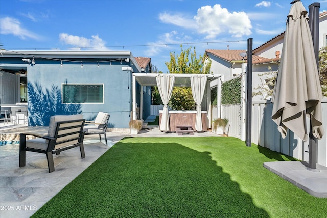 view of yard with a hot tub, a fenced backyard, and a patio