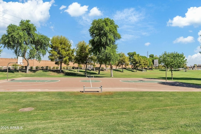 surrounding community with a yard and community basketball court