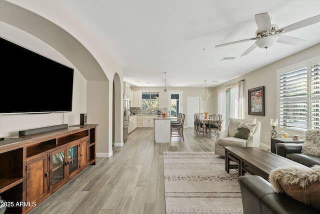 living room with light hardwood / wood-style flooring and ceiling fan