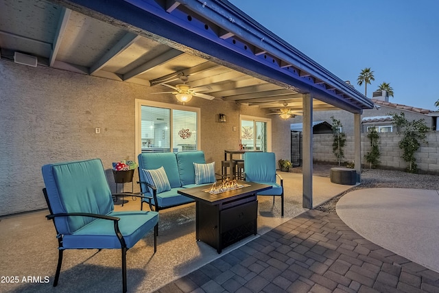 view of patio / terrace featuring ceiling fan and an outdoor living space with a fire pit