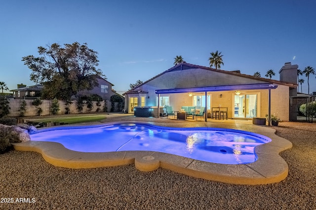 pool at dusk with an outdoor hangout area, a jacuzzi, a patio area, and french doors