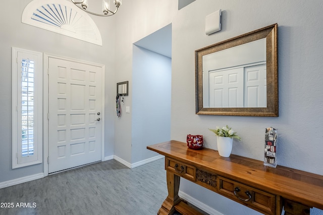 foyer entrance featuring a healthy amount of sunlight, hardwood / wood-style floors, and an inviting chandelier