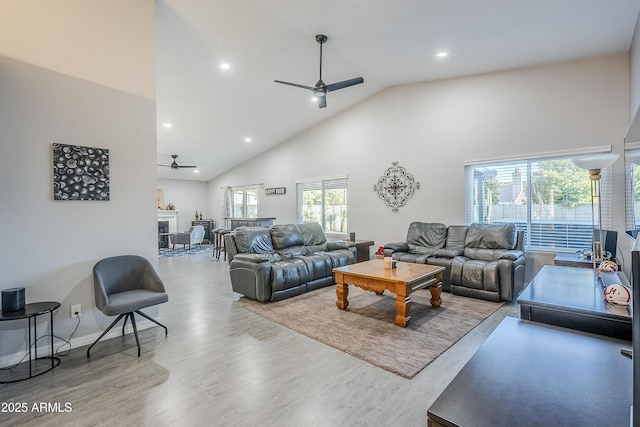 living room with hardwood / wood-style floors, high vaulted ceiling, and ceiling fan