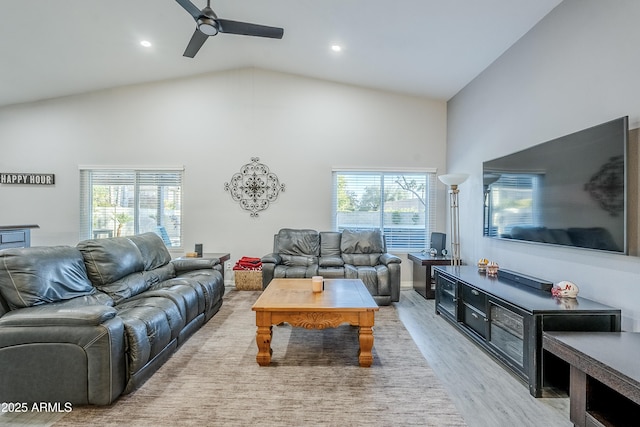 living room with light hardwood / wood-style flooring, high vaulted ceiling, and ceiling fan