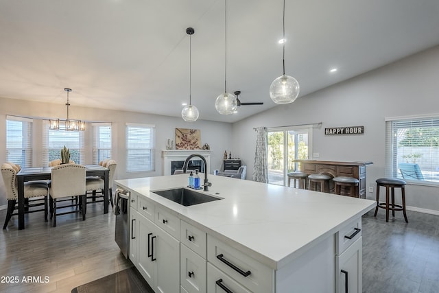 kitchen featuring sink, hanging light fixtures, a center island with sink, dishwasher, and white cabinets