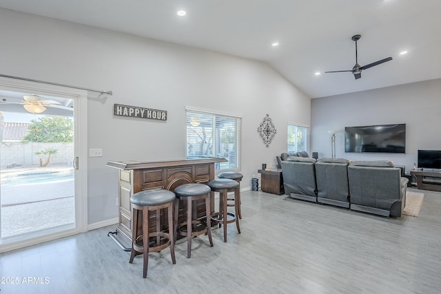 bar featuring a healthy amount of sunlight, light hardwood / wood-style floors, and ceiling fan