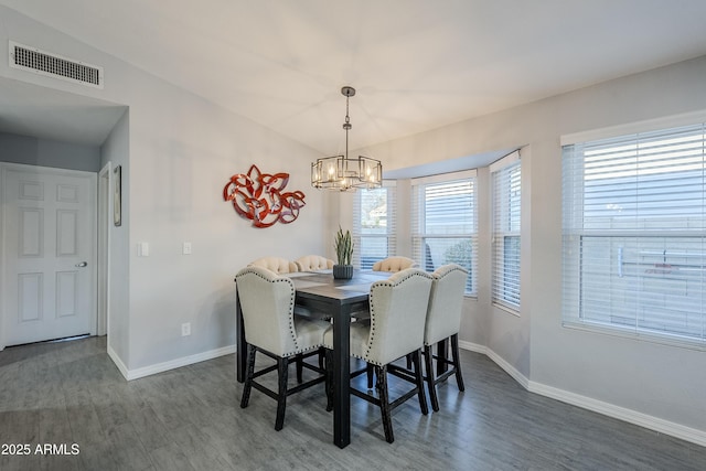 dining room with dark wood-type flooring and a notable chandelier