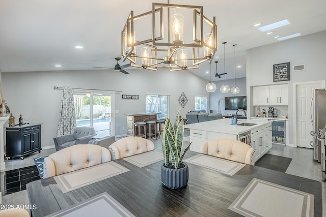 dining room with sink, high vaulted ceiling, wine cooler, dark hardwood / wood-style flooring, and ceiling fan with notable chandelier