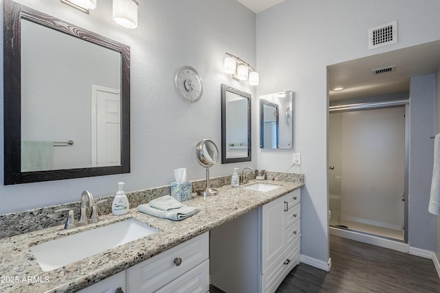 bathroom featuring hardwood / wood-style flooring, vanity, and an enclosed shower