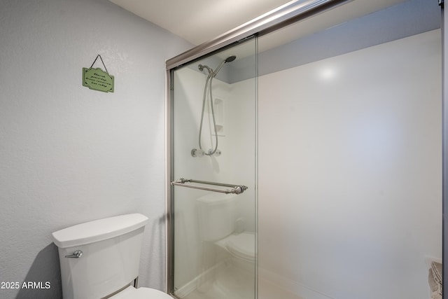 bathroom featuring toilet and walk in shower