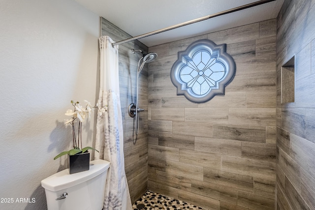 bathroom with toilet and a shower with shower curtain