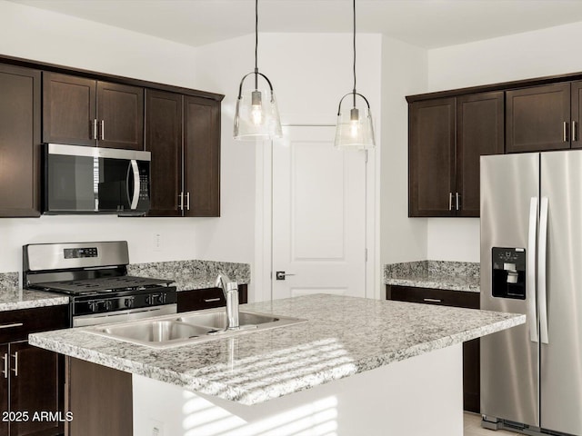 kitchen with sink, hanging light fixtures, dark brown cabinetry, stainless steel appliances, and a center island with sink