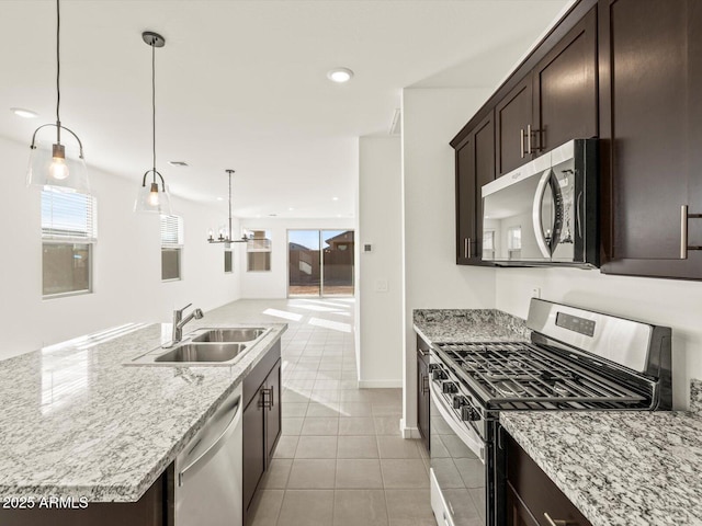 kitchen featuring light tile patterned flooring, sink, a center island, pendant lighting, and stainless steel appliances