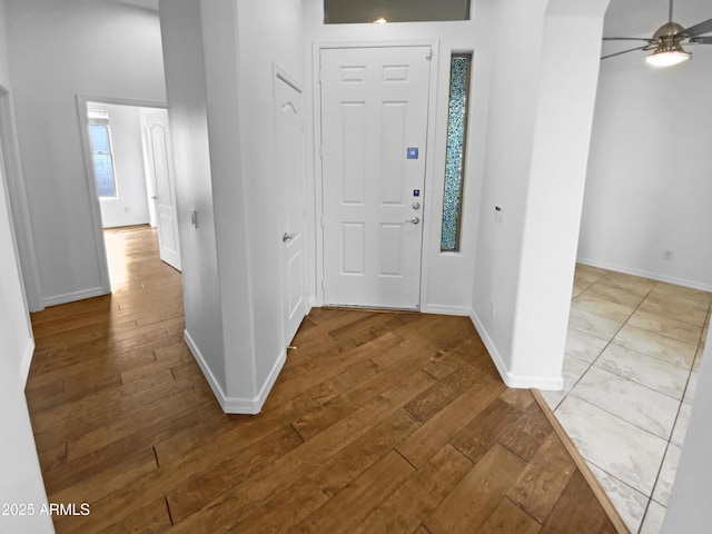 foyer featuring ceiling fan, hardwood / wood-style floors, and baseboards
