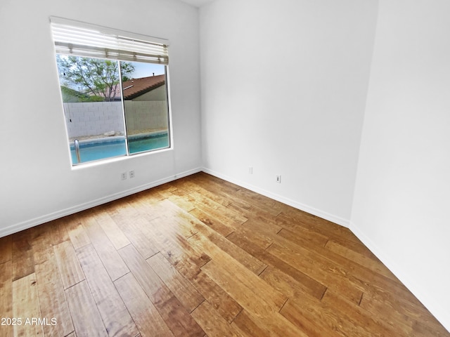 empty room featuring hardwood / wood-style flooring and baseboards