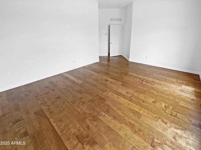 empty room featuring dark wood-type flooring and baseboards