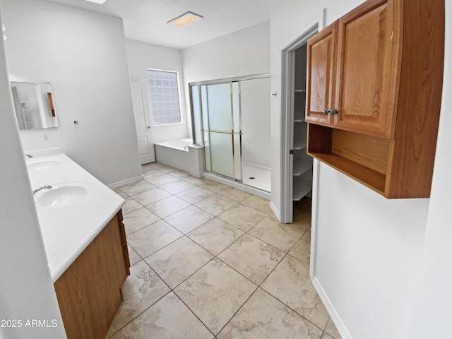 full bath with a shower stall, a bath, baseboards, and double vanity