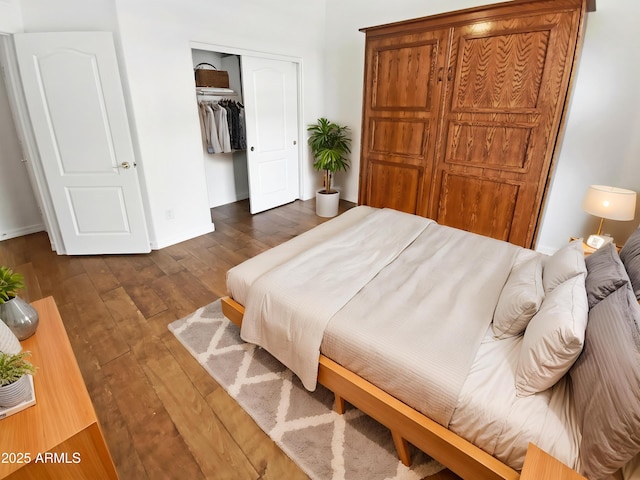 bedroom with dark wood-type flooring, a closet, and baseboards
